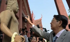 Phó Thủ tướng Campuchia Sok An xịt nước hoa lên pho tượng thần Harihara trong buổi lễ nối đầu và thân tượng ở Bảo tàng Quốc gia tại Phnom Penh. Ảnh: CNN