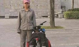Nữ sinh Yang Wanying đứng bên cạnh chiếc xe đạp đã cùng em vượt 2.500 km để tới trường đại học nhập học.