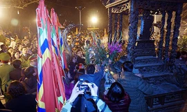 Người đi lễ lao vào cướp hoa, lộc mặc ban tổ chức đang thu dọn đồ lễ. Ảnh: Giang Huy.