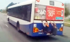 Hai đứa trẻ đánh đu đuôi xe buýt trốn vé