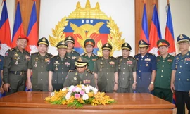 Phó Thủ tướng kiêm Bộ trưởng Bộ Quốc phòng Campuchia Tea Banh viết sổ lưu niệm cho tòa nhà. (Ảnh: Minh Hưng/TTXVN)