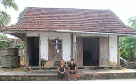 Phương và bà ngoại bên căn nhà vách đất ọp ẹp. Ảnh: Đức Hùng