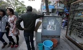 Biển cảnh báo "Nguy hiểm chết người" trên hộp điện này không có ý nghĩa gì với người đàn ông này (Ảnh chụp tại phố Lương Văn Can).