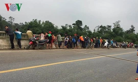 Người dân tập trung trên cầu Địa Lợi theo dõi việc tìm kiếm thầy giáo H.