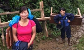 Trời mưa to khiến đường lầy và trơn trượt, các cô giáo phải mặc áo mưa và đi ủng để cõng bàn ghế đến điểm trường cho học sinh.