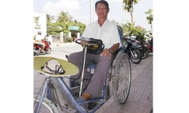 Ông Nguyễn Xuân Trương chật vật bên chiếc xe lắc của mình đi bán vé số để làm từ thiện. 