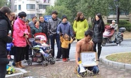 Người đàn ông quỳ gối trước khu nhà vợ con mình ở để xin lỗi.