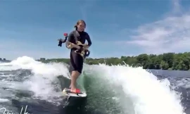 Chàng trai vừa lướt ván, vừa chơi đàn guitar