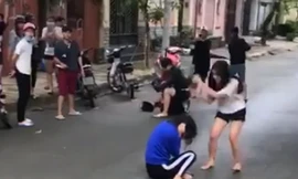 Nữ sinh áo tráng dùng mũ bảo hiểm đánh tới tấp vào đầu nữ sinh áo xanh trước chứng kiến của nhiều người 