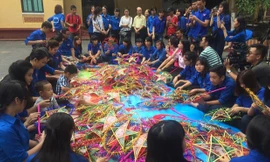 Các bệnh nhi được các tình nguyện viên hướng dẫn làm đèn trung thu tại sân bệnh viện