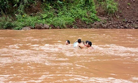 Các bậc phụ huynh liều mình đưa con qua suối kịp khai giảng năm học mới. Ảnh: baolaichau.vn