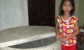 Cháu Thủy bên giếng nước mà cháu bị rơi xuống. 