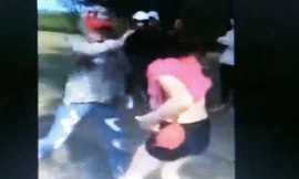 Hình ảnh nữ sinh Nguyễn Thị Q. túm tóc dùng mũ bảo hiểm đánh bạn tơi tả bị đình chỉ học 1 năm. Ảnh cắt từ clip