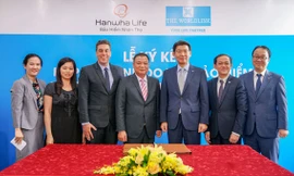Ông Back Jong Kook (Thứ 3, bìa phải), Chủ tịch Hội đồng thành viên kiêm Tổng giám đốc Hanwha Life Việt Nam, chúc mừng đại diện đối tác Worldlink tại lễ ký kết hợp tác chiến lược ngày 26-7.