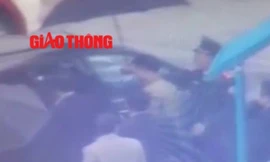 Lực lượng an ninh dẫn giải Vũ “nhôm” ra xe ô tô (ảnh cắt từ clip Báo Giao thông)
