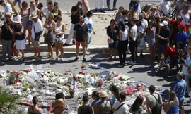 Người dân đứng quanh khu vực đặt hoa tưởng niệm các nạn nhân thiệt mạng trong vụ tấn công khủng bố ở Nice.