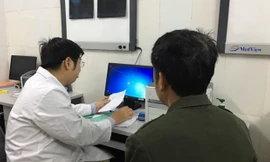 Bác sĩ Nguyễn Trần Trung khám bệnh cho bệnh nhân gout. Ảnh: HQ.