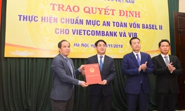 Đại diện Ban Lãnh đạo NHNN, ông Đoàn Thái Sơn – Phó Thống đốc (ngoài cùng bên trái) trao quyết định công nhận Vietcombank thực hiện chuẩn mực an toàn vốn Basel II (đại diện Ban Lãnh đạo Vietcombank nhận quyết định: Ông Nghiêm Xuân Thành – Chủ tịch