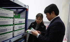 Thầy cô giáo tại một điểm trường tiểu học Hà Nội cẩn thận kiểm tra chất lượng sữa trước giờ xuất sữa cho học sinh tham gia chương trình uống sữa học đường