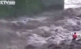 Người đàn ông đương đầu với dòng nước lũ cuồn cuộn