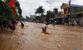 Người dân vớt hàng trên quốc lộ 6. Ảnh: N.N