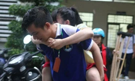 Xúc động, tình nguyện viên cõng nữ sinh gãy chân leo cầu thang