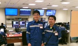 Kỹ sư Đàm Gia Phong (trái) và kỹ sư Nguyễn Phú Đại hỗ trợ vận hành tại phòng Điều khiển trung tâm NMLD Nghi Sơn