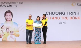 Ông Larry Madge - Tổng Giám đốc Sun Life Việt Nam và Hoa hậu H'Hen Niê trao biểu trưng trụ bóng rổ cho trường Trung học phổ thông Hoàng Văn Thụ, Hà Nội.