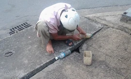 "Thợ câu” Nguyễn Quốc Minh đang “tác nghiệp” qua khe hở của miệng ống cống thoát nước trên đường Cách Mạng Tháng Tám (phường Quyết Thắng, TP.Biên Hòa, Đồng Nai).