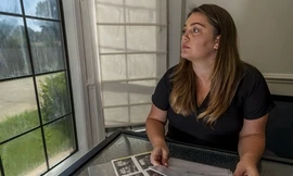 Heven Lunsford cầm ảnh siêu âm và giấy in dấu chân, dấu tay con trai chưa chào đời tại nhà riêng ở Alabama hôm 29/8. Ảnh: AP.