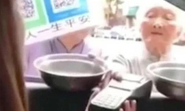 Một cụ bà ăn xin bằng smartphone