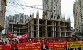 Hàng trăn khách hàng căng băng rôn đòi nhà. Ảnh: Minh Đức