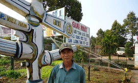 Ông Tám đứng trước mô hình béc tưới tự chế
