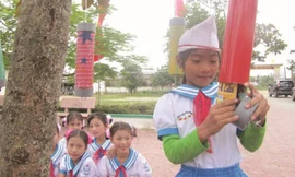 Học sinh trường Trường tiểu học Tân Lộc thích thú “hái” sách báo trên cây để đọc. Ảnh: Nguyên Dũng.