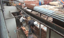 Phần bức tường bị cần cẩu làm sập