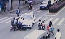 Hàng chục người nâng ôtô cứu cụ ông bị cuốn vào gầm