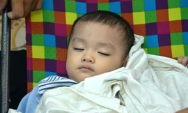 Cháu bé bị bỏ rơi trên taxi được một cán bộ phường đưa về nhà chăm sóc, chờ quyết định cuối cùng về tương lai cháu bé. Ảnh: Việt Văn.