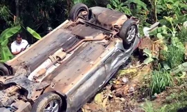 Xe 7 chỗ lật ngửa, tài xế kẹt cứng bên trong . Ảnh: Thái Hà.