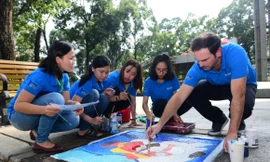 Ông Matt Wilson - Giám đốc Ngoại vụ cấp cao HEINEKEN Việt Nam cùng các tình nguyện viên vẽ trang trí nắp hầm ga trong chương trình “1 Phút Tiết Kiệm Triệu Niềm Vui”