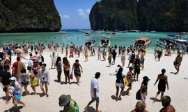 Hàng loạt du khách xếp hàng trên bãi cát để đợi lượt lên thuyền cao tốc vào buổi sáng. Ảnh: AFP.