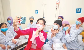 Hoa hậu Đỗ Thị Hà chụp ảnh cùng các bệnh nhân khi thăm tặng quà tại Viện Huyết học và Truyền máu T.Ư Ảnh: Như Ý