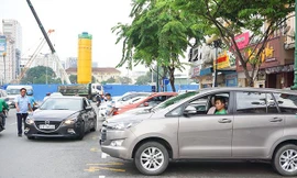 Nhân viên đô thị hướng dẫn tài xế cho xe vào bãi đỗ có thu phí