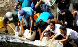 Người dân Venezuela đang hứng nước từ một miệng cống ảnh: Carlos Rawlins