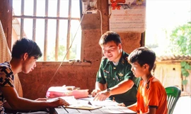 “Thầy giáo cắm bản” Hoàng Văn Tú dạy các em học bài ảnh: Duy Chiến 