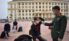 Đo thân nhiệt khi tiếp nhận công dân vào khu cách ly Ảnh: PV