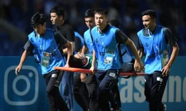 Phóng viên bị CĐV ném đá trúng đầu phải rời sân bằng cáng.