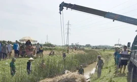 Chiếc xe máy cày chở đầy lúa bị lật xuống mương nước