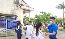 Học sinh được đo thân nhiệt trước khi vào lớp học.