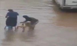 Chồng lội nước bì bõm bắc ghế cho vợ qua đường ngập