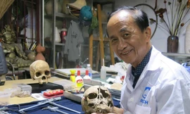 PGS.TS. Nguyễn Lân Cường và sọ bé gái tiền sử 4 tuổi đã được phục nguyên.